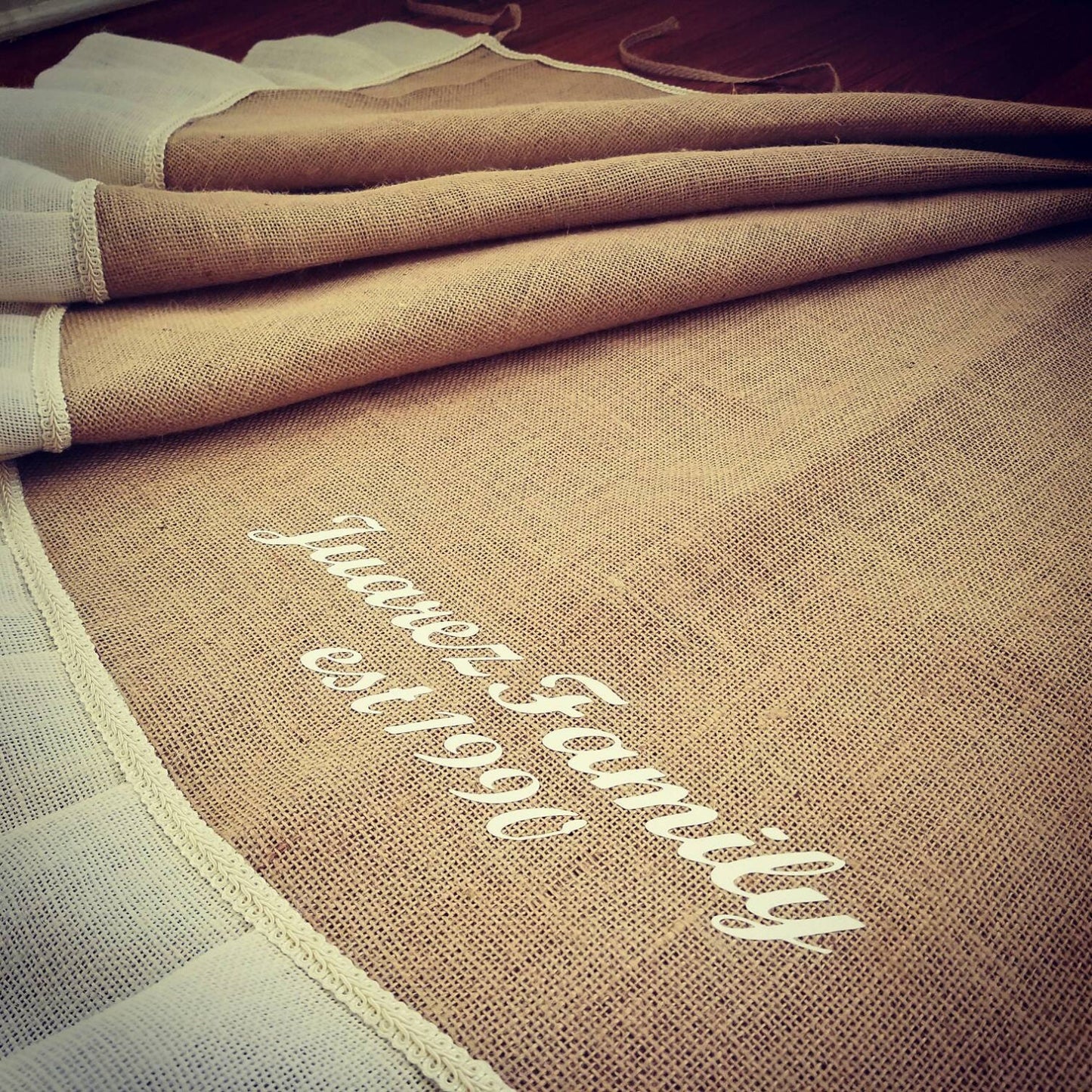 Tan Burlap Christmas Tree Skirt with White outer ruffle. Skirt is personalized with family name, The Juarez Family. Established 1990.