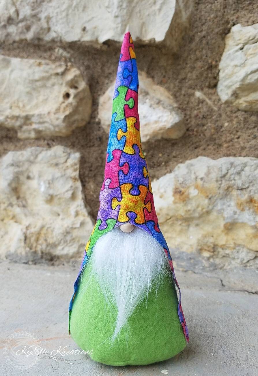 Autism Awareness Gnome with colorful puzzle piece hat, white beard and lime green body.