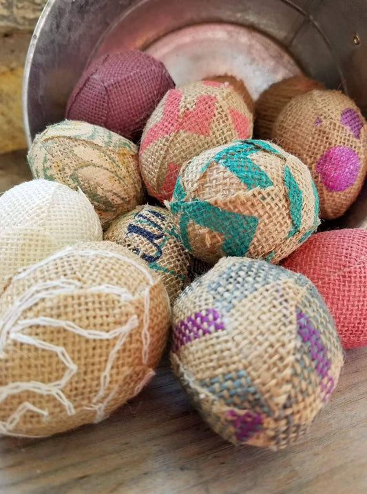 Handmade Burlap Easter Eggs in pastel colors, pinks, purples, aqua, tan and creams. Displayed overflowing in tin bucket.