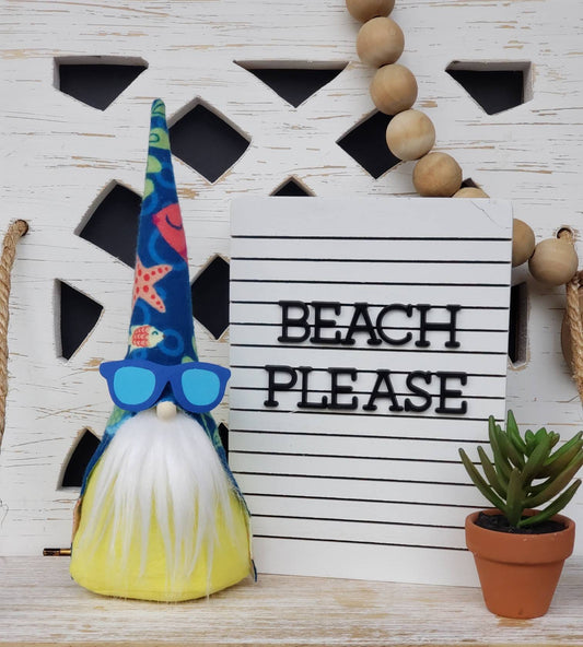 Beach Gnome with white beard & yellow body. This handmade KyElle Kreations gnome measures 9 inches. Displayed with faux foliage and seasonal accent decor.