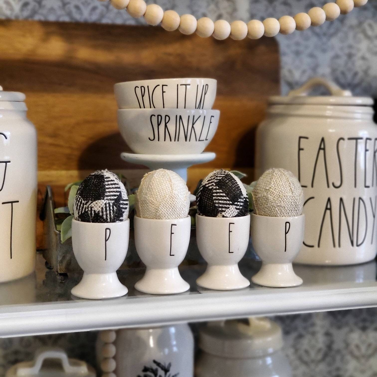 Handmade Burlap Easter Eggs in Black & White Buffalo Plaid . Displayed in ceramic egg cups.