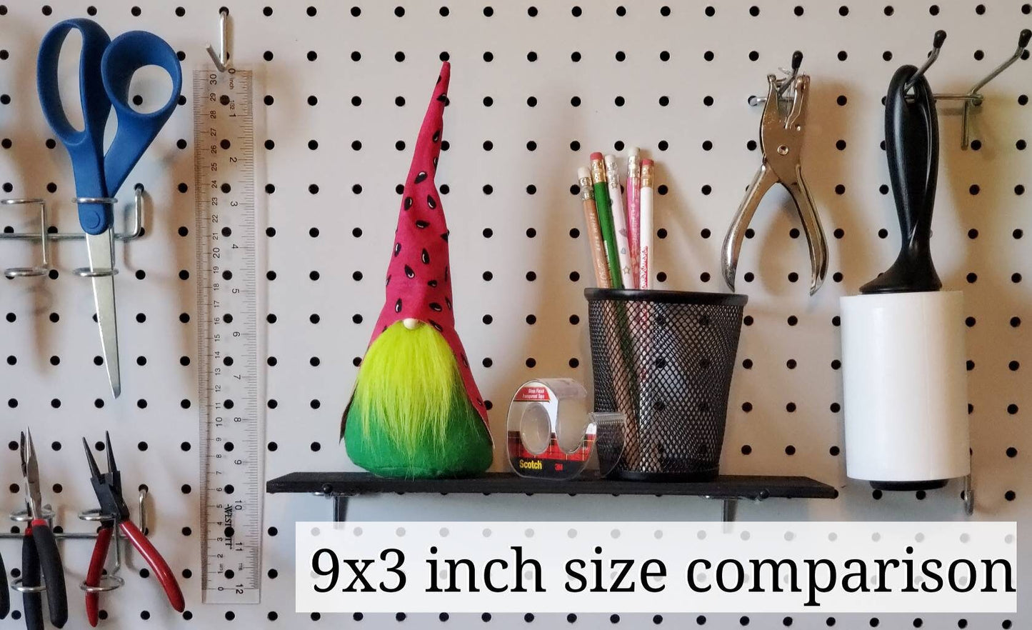 Size comparison for 9 inch Gnome next to everyday household items such as pencils, a pair of scissors, lint roller & a ruler.