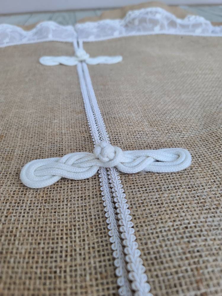 Close up of ivory frog claps closures upon burlap and lace tree skirt.