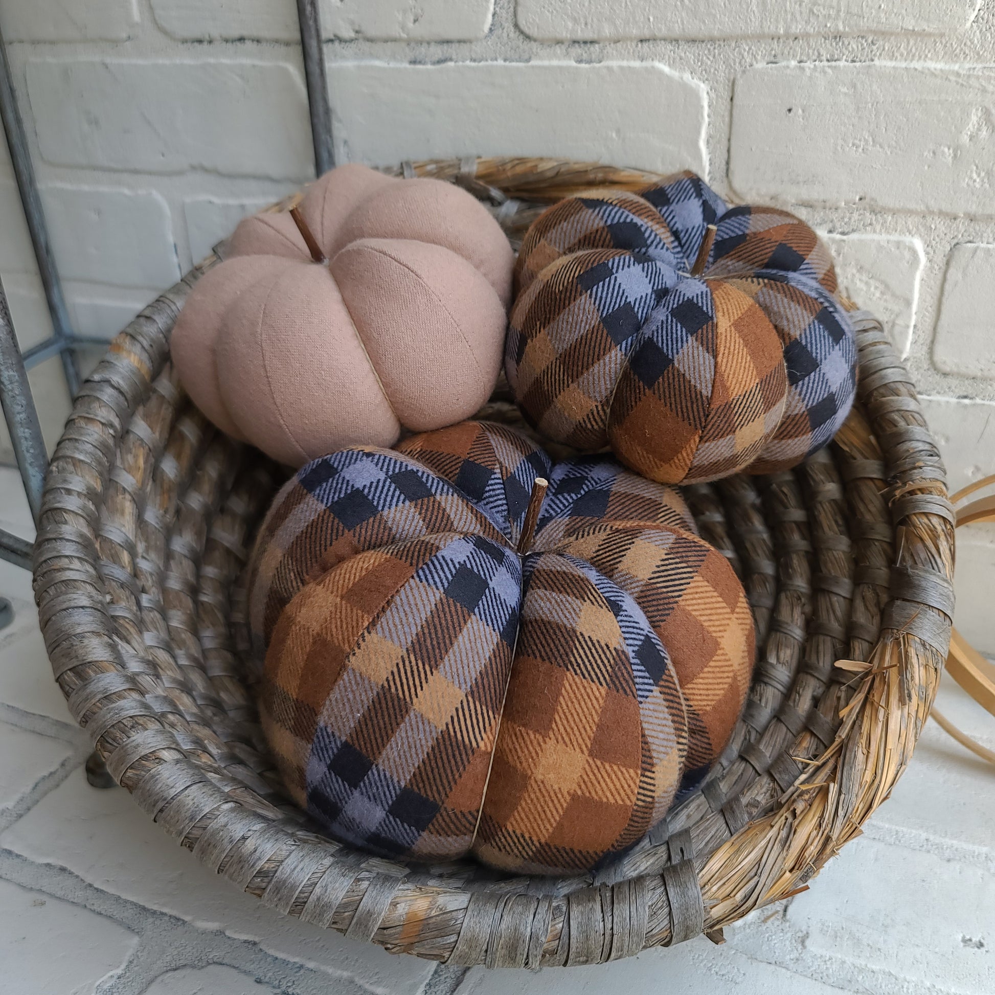 Pumpkin trio set in Chocolate plaid. One large & one small in Chocolate plaid and one small in solid tan color. Displayed in hand woven basket