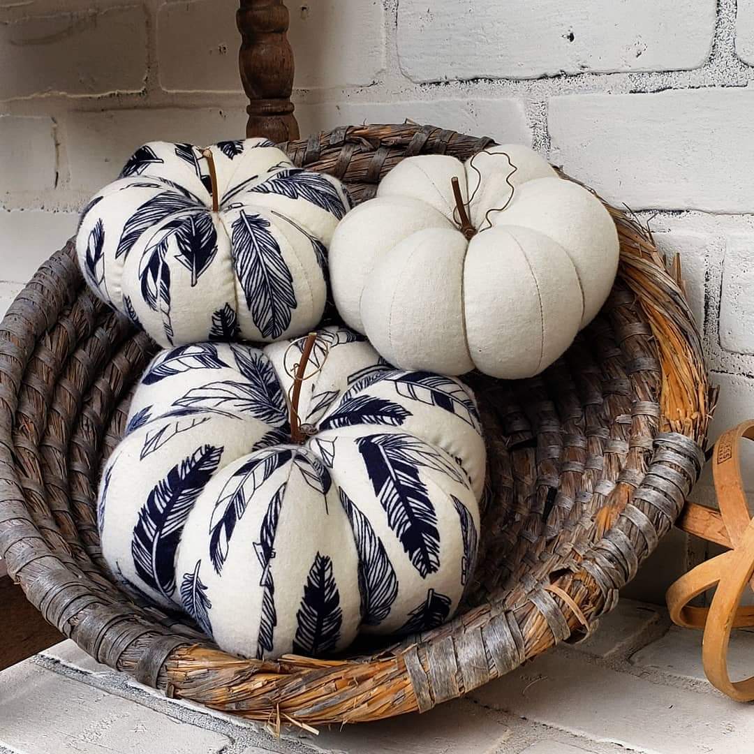 Handmade pumpkin trio, one large and 1 small in cream base and navy feather print. Third pumpkin in solid cream color. Displayed in hand woven basket