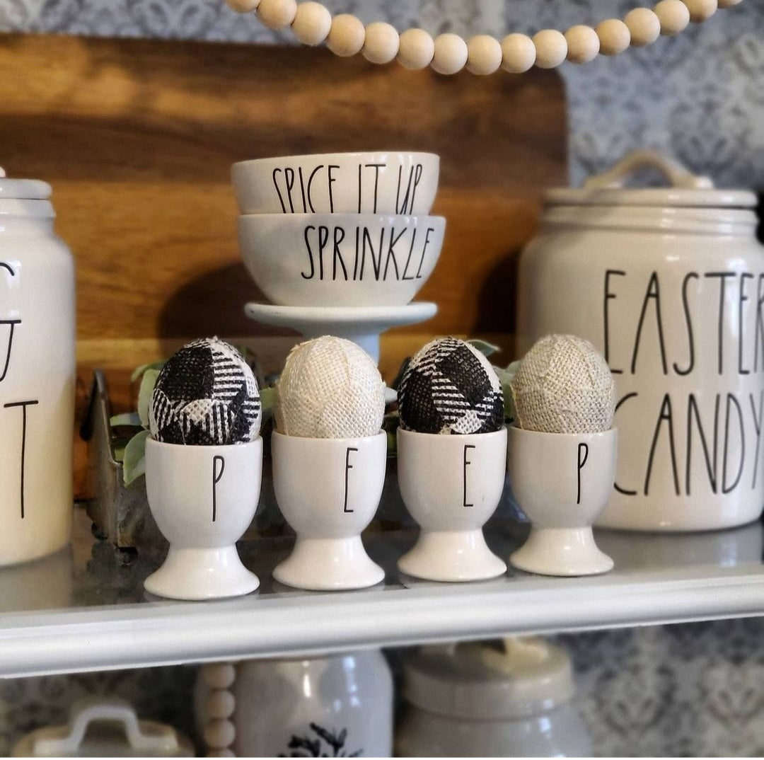Handmade Burlap Easter Eggs in Black & White Buffalo Plaid . Displayed in ceramic egg cups.