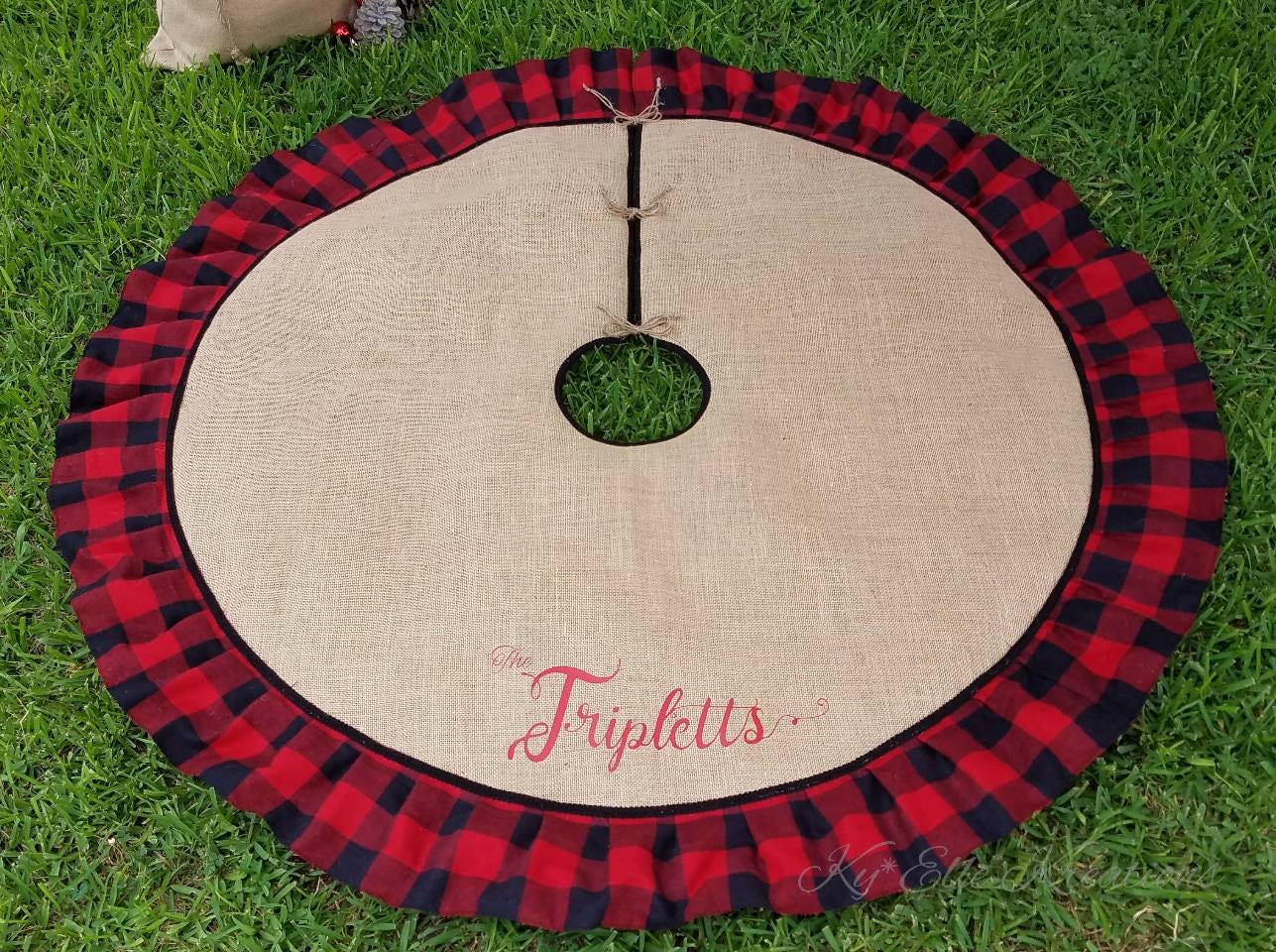 Full diameter view of Red & Black Buffalo Plaid, Burlap Christmas Tree Skirt displayed with personalized family name, The Triplets in red,