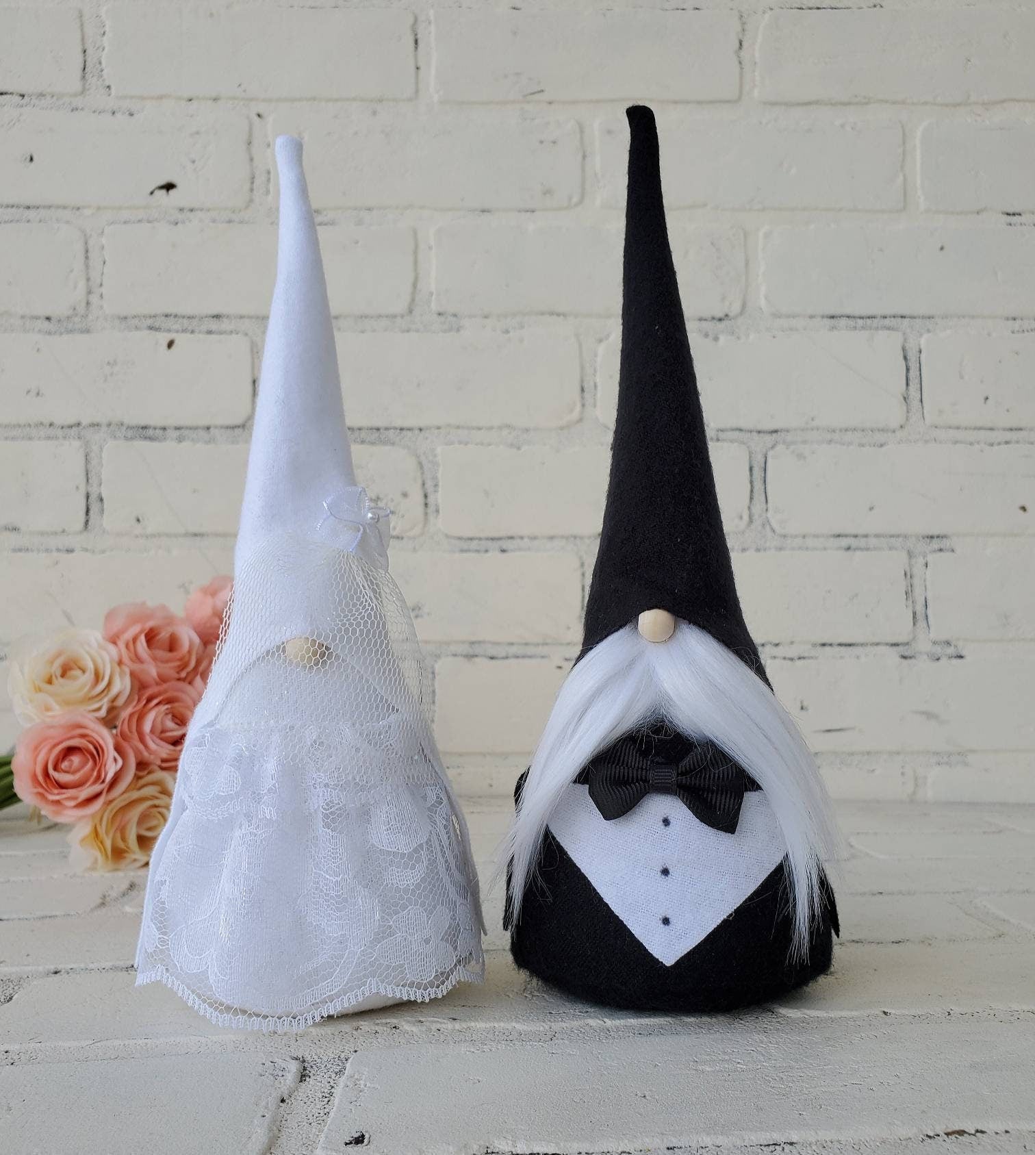 Bride and Groom Gnome set complete with groom in tux & tie. Bride is fully adorned in lace dress and veil. With pink & cream rose bouquet accented in background