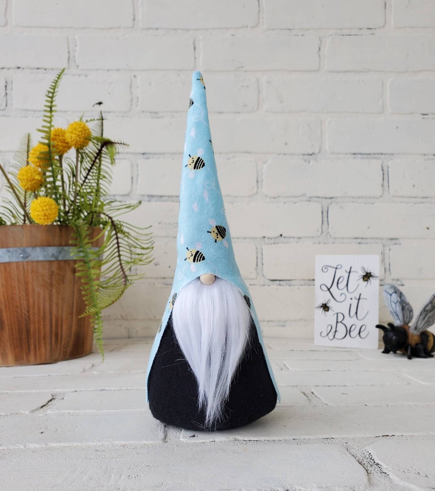 Bumble Bee Gnome with white beard & black body. This handmade KyElle Kreations gnome measures 9 inches.. Displayed with faux foliage and seasonal accent decor. 